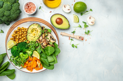 A colorful plate featuring a variety of fresh vegetables, creamy avocado, and assorted ingredients arranged artfully.